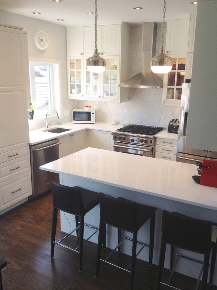 Example of a small transitional l-shaped dark wood floor eat-in kitchen design in Montreal with an undermount sink, shaker cabinets, white cabinets, quartz countertops, gray backsplash, mosaic tile backsplash, stainless steel appliances and an island