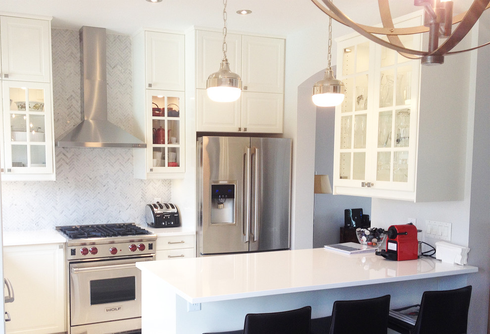 This is an example of a small classic l-shaped kitchen/diner in Montreal with a submerged sink, shaker cabinets, white cabinets, engineered stone countertops, grey splashback, mosaic tiled splashback, stainless steel appliances, dark hardwood flooring and an island.