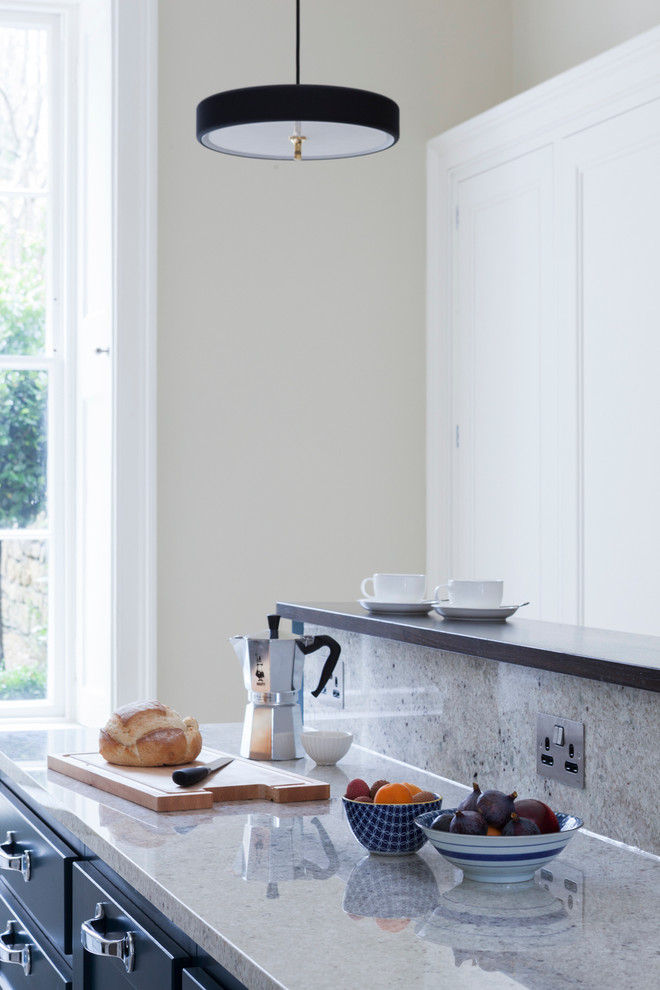Foto på ett mellanstort funkis linjärt kök, med rostfria vitvaror och en köksö