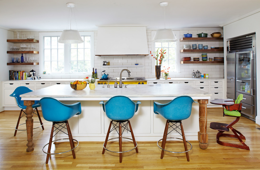Moderne Küche in L-Form mit flächenbündigen Schrankfronten, weißen Schränken, Küchenrückwand in Weiß, Rückwand aus Metrofliesen und Küchengeräten aus Edelstahl in Birmingham
