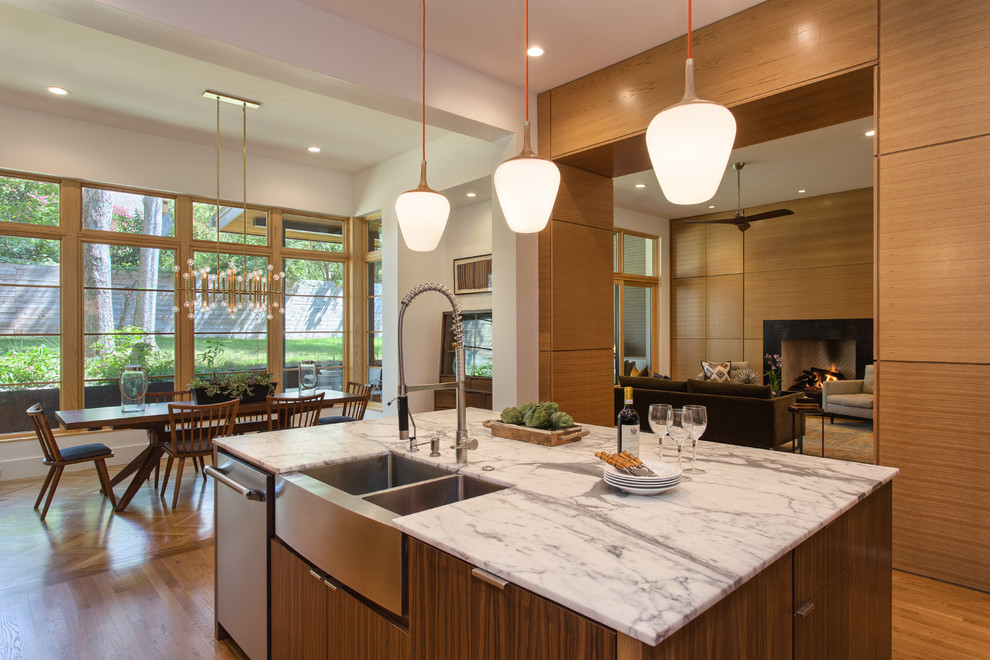 Foto di un cucina con isola centrale design con ante in legno scuro, elettrodomestici in acciaio inossidabile e pavimento in legno massello medio