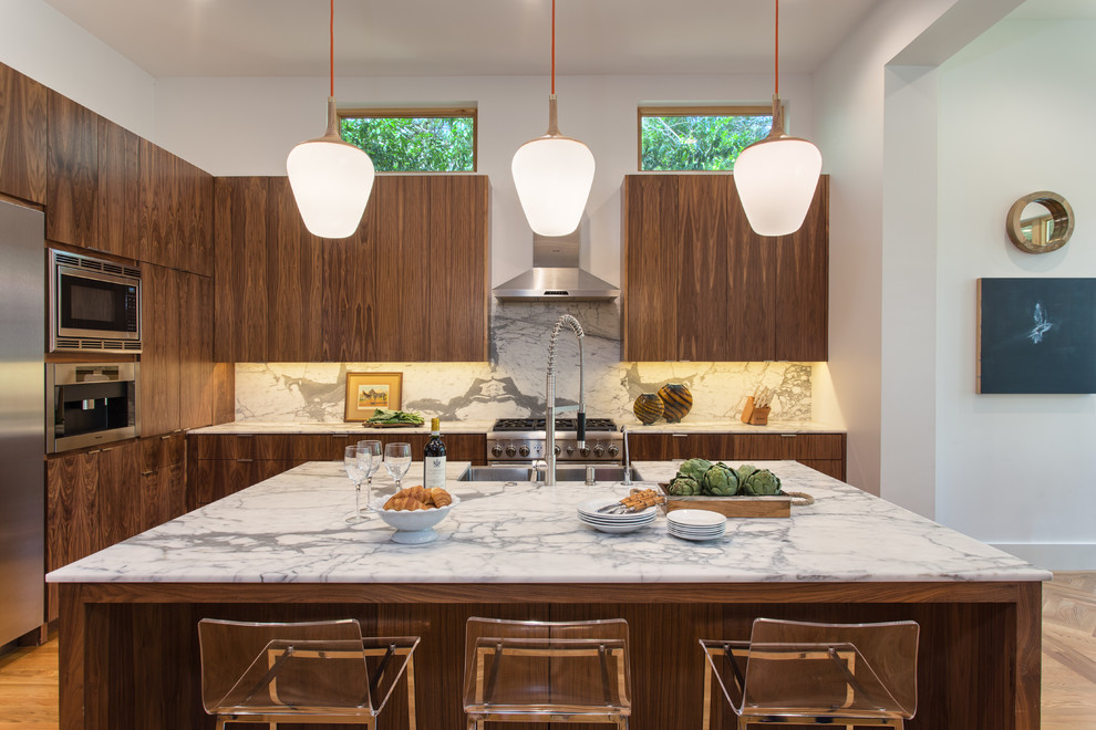 Example of a trendy kitchen design in Austin with medium tone wood cabinets, stainless steel appliances, an island, flat-panel cabinets and multicolored backsplash