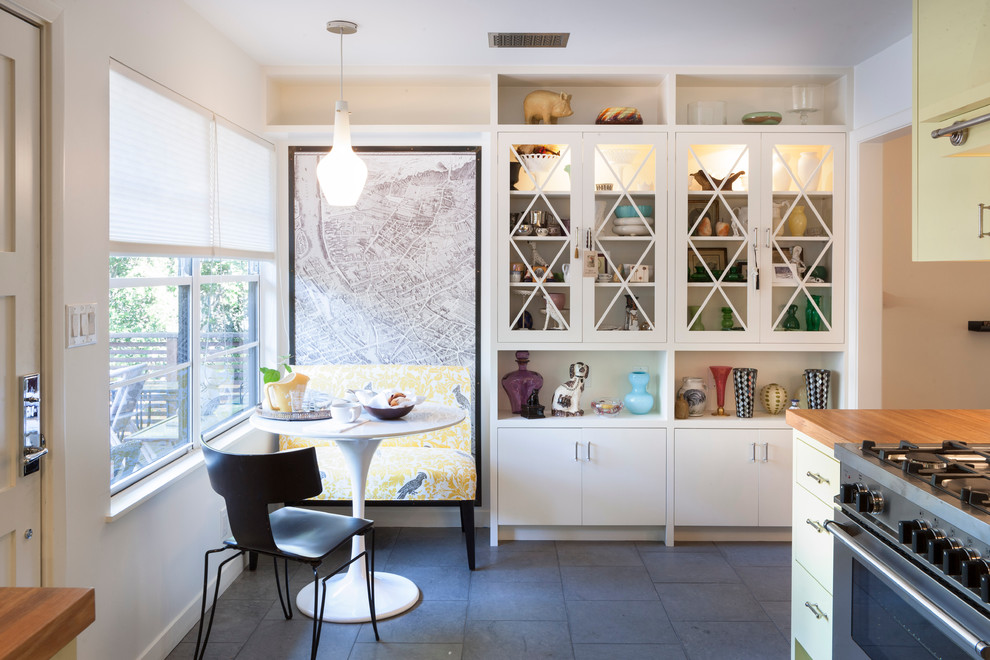 オースティンにあるコンテンポラリースタイルのおしゃれなキッチン (ガラス扉のキャビネット、木材カウンター、黄色いキャビネット) の写真