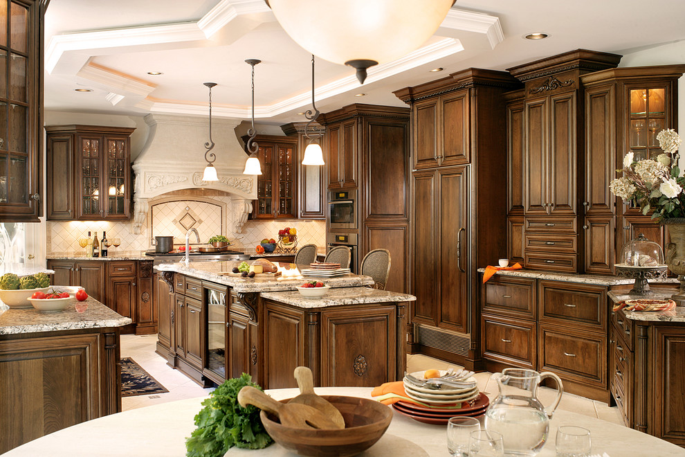 Exempel på ett stort kök, med en undermonterad diskho, luckor med upphöjd panel, bruna skåp, granitbänkskiva, beige stänkskydd, stänkskydd i keramik, integrerade vitvaror, klinkergolv i keramik och en köksö