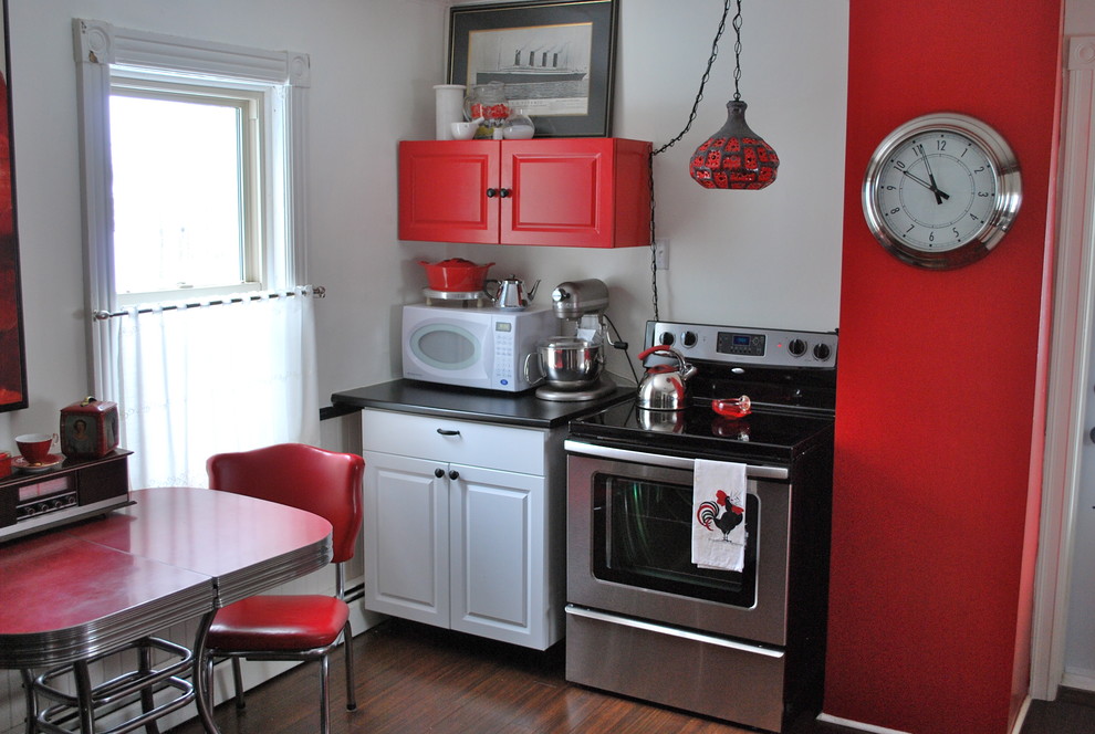 Example of an eclectic kitchen design in Other with stainless steel appliances and red cabinets