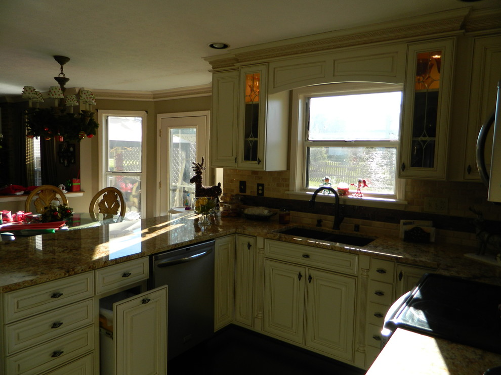 Photo of a large traditional u-shaped kitchen/diner in Louisville with a submerged sink, raised-panel cabinets, white cabinets, granite worktops, beige splashback, stone tiled splashback and stainless steel appliances.