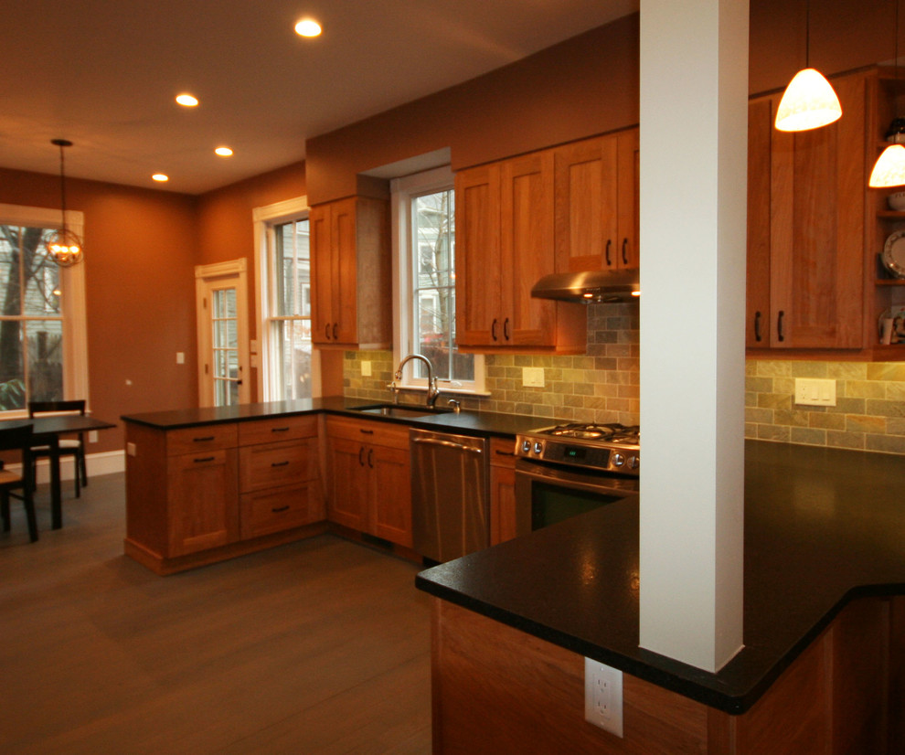 Mid-sized transitional u-shaped medium tone wood floor eat-in kitchen photo in Boston with an undermount sink, shaker cabinets, medium tone wood cabinets, granite countertops, multicolored backsplash, stone tile backsplash, stainless steel appliances and a peninsula