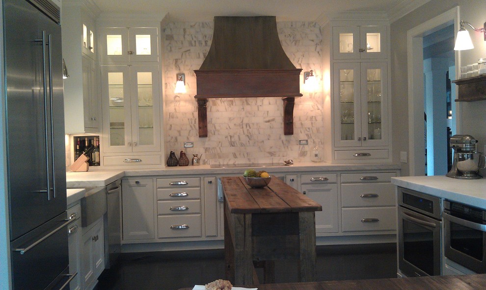 Elegant kitchen photo in Raleigh with a farmhouse sink, recessed-panel cabinets, beige cabinets, marble countertops and an island