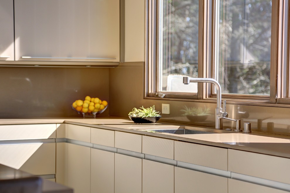Esempio di una grande cucina minimal con lavello a vasca singola, ante lisce, top in quarzo composito, paraspruzzi grigio e elettrodomestici in acciaio inossidabile