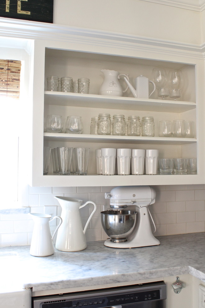 Immagine di una cucina abitabile tradizionale con lavello stile country, nessun'anta, ante bianche, top in marmo, paraspruzzi bianco e elettrodomestici in acciaio inossidabile