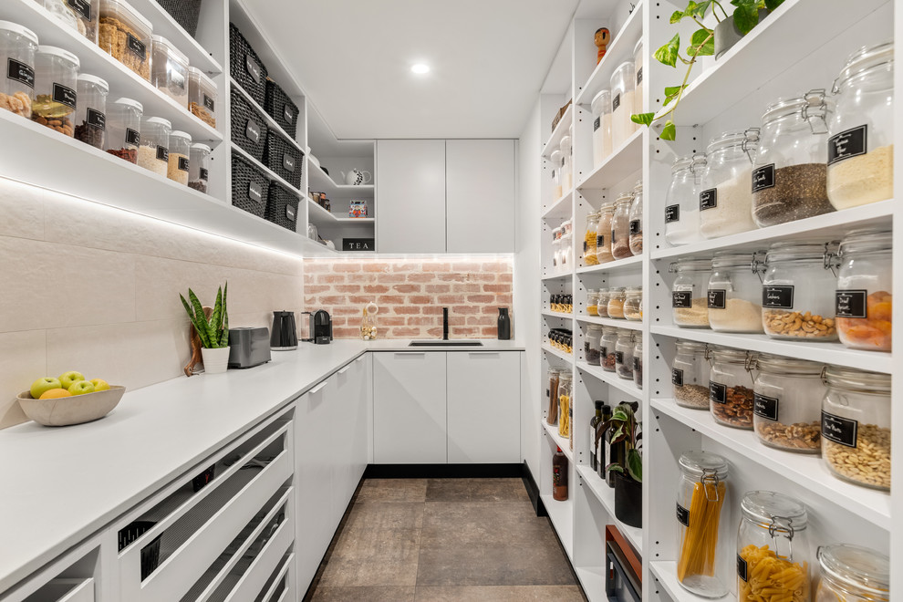 Moderne Küche mit Vorratsschrank, Unterbauwaschbecken, offenen Schränken, weißen Schränken, Küchenrückwand in Beige, braunem Boden, weißer Arbeitsplatte und Rückwand aus Backstein in Perth