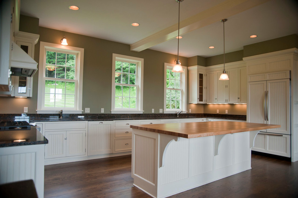 Large cottage u-shaped dark wood floor and brown floor eat-in kitchen photo in Boston with an undermount sink, shaker cabinets, white cabinets, granite countertops, black backsplash, stone slab backsplash, paneled appliances and an island