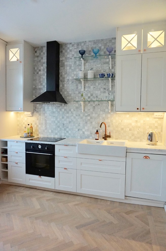 Foto på ett mellanstort vintage grå linjärt kök och matrum, med en rustik diskho, skåp i shakerstil, vita skåp, marmorbänkskiva, grått stänkskydd, stänkskydd i marmor, svarta vitvaror, ljust trägolv och beiget golv