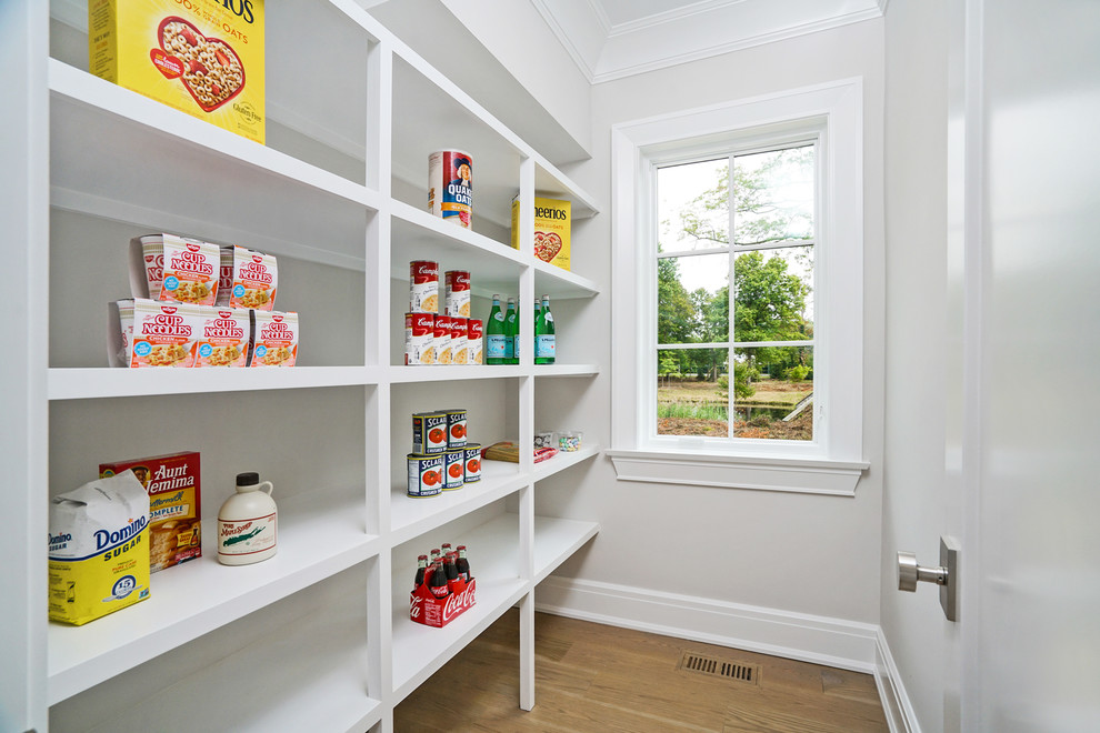 Example of a mid-sized transitional single-wall light wood floor and brown floor kitchen pantry design in New York