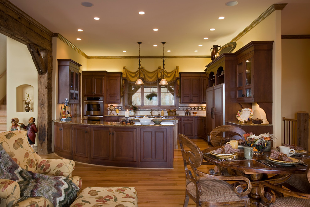 Exempel på ett stort rustikt kök, med en integrerad diskho, luckor med infälld panel, skåp i mörkt trä, granitbänkskiva, vitt stänkskydd, stänkskydd i keramik, rostfria vitvaror, ljust trägolv och en köksö