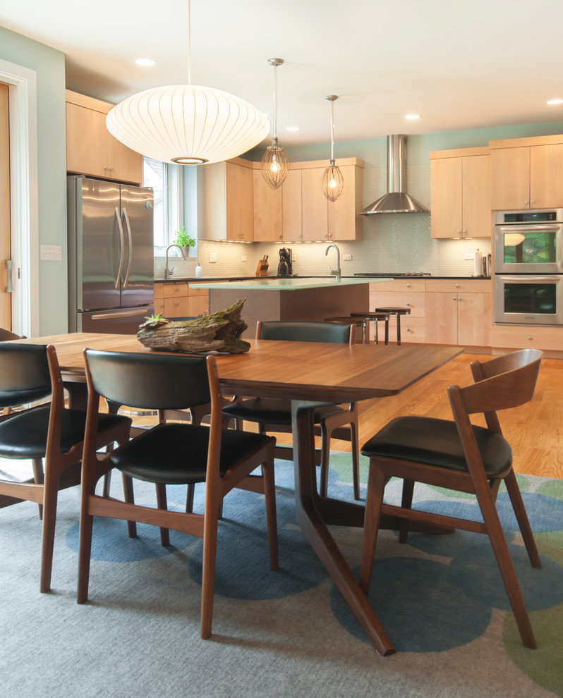 Foto di una cucina moderna con ante lisce, ante in legno chiaro, paraspruzzi verde e elettrodomestici in acciaio inossidabile