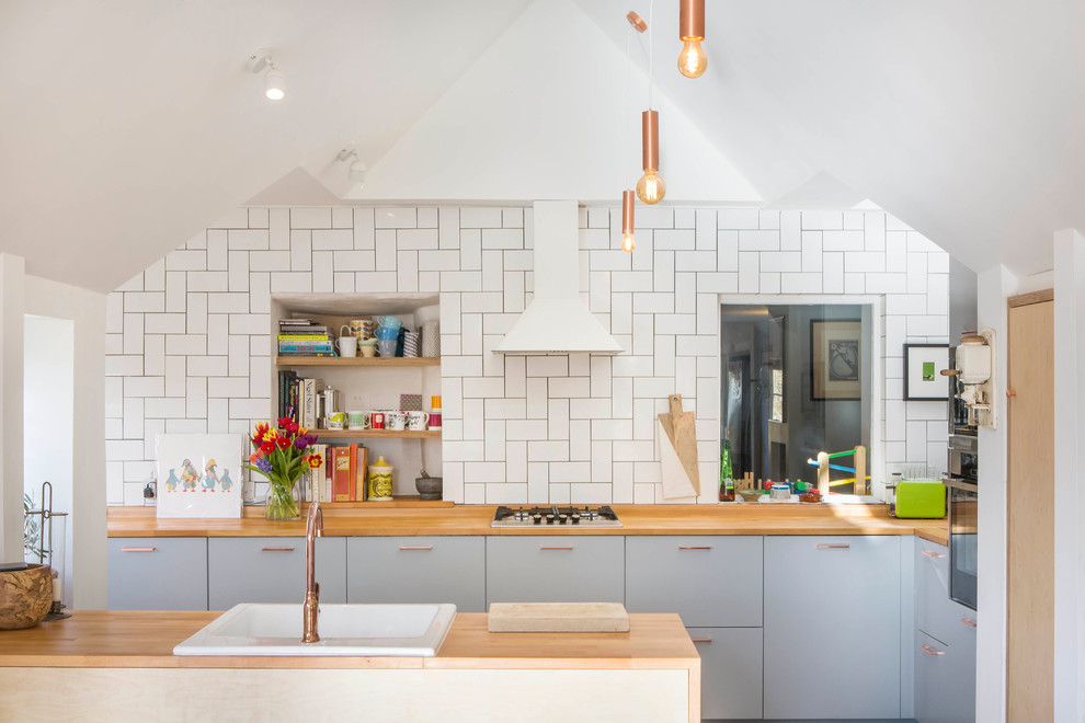 Nordische Küche mit Einbauwaschbecken, flächenbündigen Schrankfronten, blauen Schränken und Küchenrückwand in Weiß in Oxfordshire
