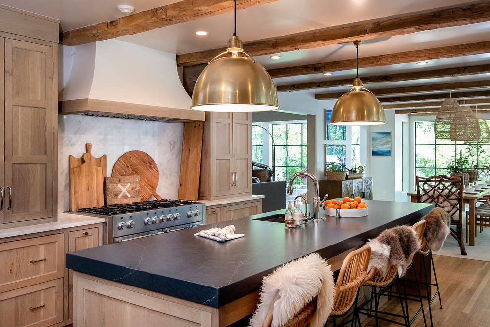 Mid-sized cottage u-shaped light wood floor and brown floor eat-in kitchen photo in Other with an undermount sink, shaker cabinets, light wood cabinets, quartz countertops, white backsplash, stone slab backsplash, stainless steel appliances, an island and black countertops