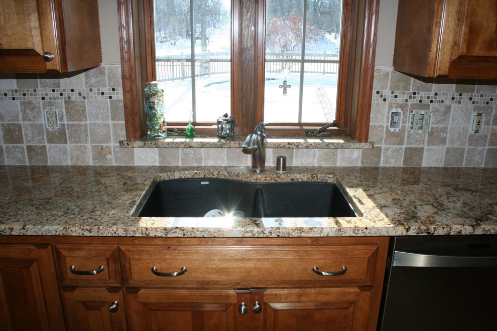 Example of a mid-sized trendy u-shaped porcelain tile eat-in kitchen design in Milwaukee with an undermount sink, louvered cabinets, medium tone wood cabinets, granite countertops, beige backsplash, stone tile backsplash, stainless steel appliances and no island