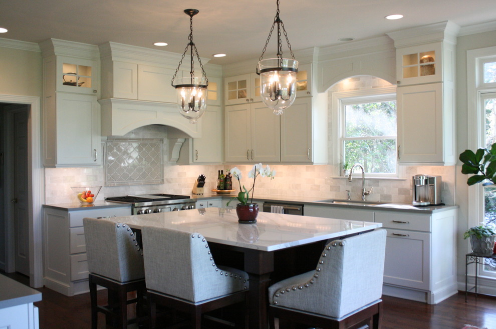 This is an example of a medium sized traditional kitchen in Nashville with a submerged sink, flat-panel cabinets, engineered stone countertops, white splashback, metro tiled splashback, integrated appliances, dark hardwood flooring and an island.