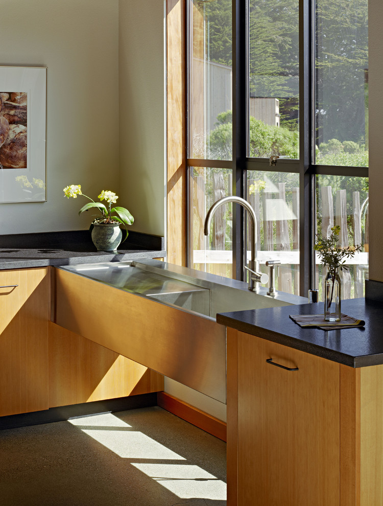 Ejemplo de cocina contemporánea con fregadero integrado, armarios con paneles lisos y puertas de armario de madera oscura