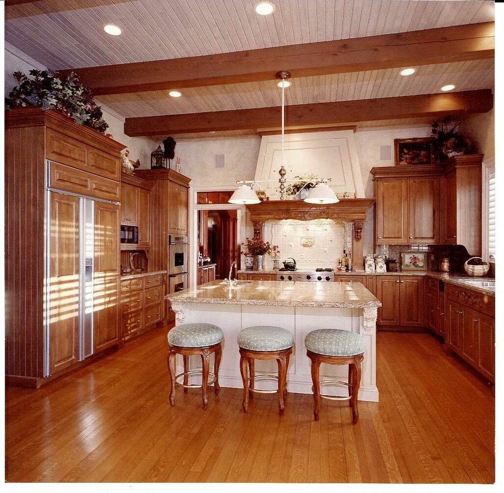Idéer för ett stort klassiskt kök, med en undermonterad diskho, luckor med upphöjd panel, skåp i mellenmörkt trä, granitbänkskiva, vitt stänkskydd, stänkskydd i stenkakel, rostfria vitvaror, mellanmörkt trägolv och en köksö