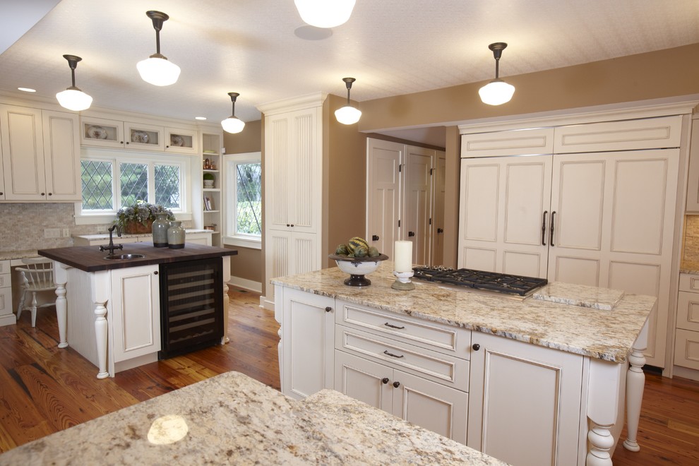 Exemple d'une cuisine encastrable chic avec un placard avec porte à panneau encastré, des portes de placard blanches et une crédence beige.
