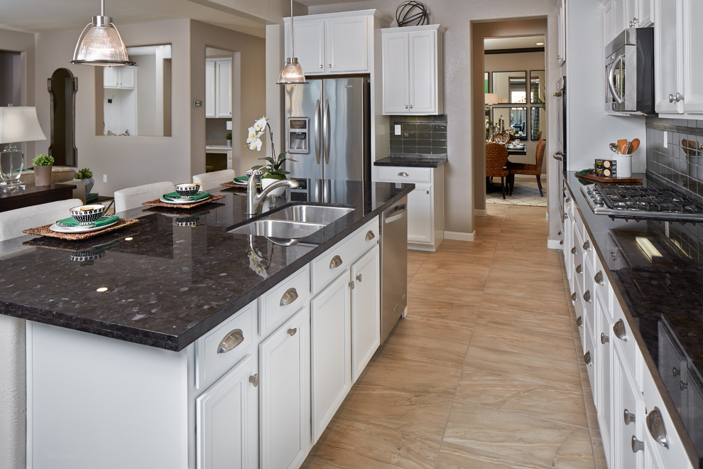 Inspiration for a classic u-shaped kitchen in San Francisco with white cabinets, granite worktops, stainless steel appliances, ceramic flooring and an island.