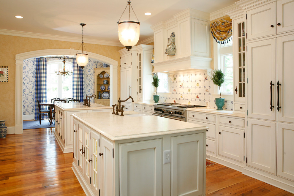 Modelo de cocina clásica con armarios con rebordes decorativos, puertas de armario blancas y electrodomésticos con paneles