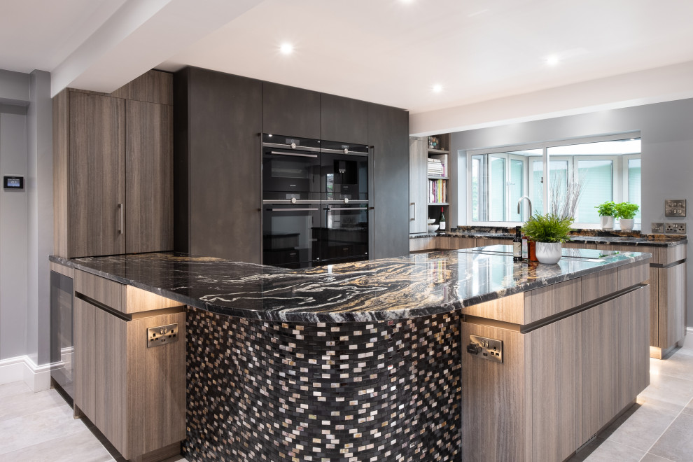 Design ideas for a medium sized contemporary u-shaped enclosed kitchen in Gloucestershire with flat-panel cabinets, grey cabinets, granite worktops, black appliances, porcelain flooring, no island, grey floors, multicoloured worktops and a submerged sink.