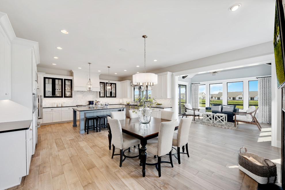 Eat-in kitchen - large coastal u-shaped light wood floor eat-in kitchen idea in Chicago with a farmhouse sink, white cabinets, granite countertops, stainless steel appliances and an island