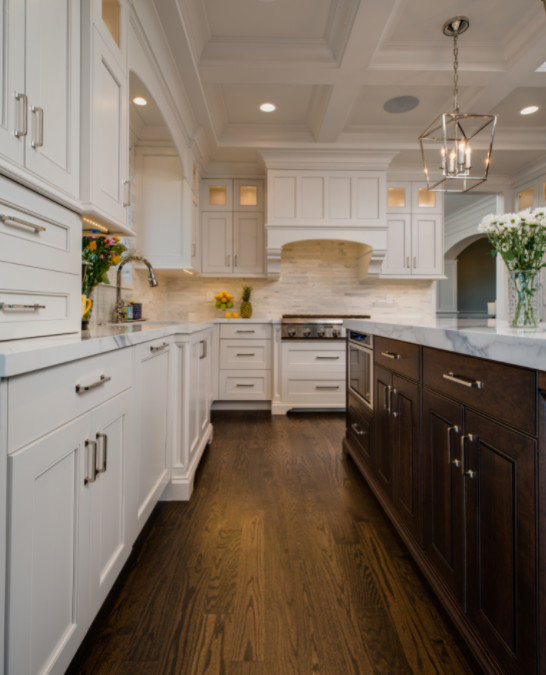 Photo of a large traditional u-shaped open plan kitchen in Detroit with a submerged sink, shaker cabinets, white cabinets, marble worktops, white splashback, matchstick tiled splashback, white appliances, dark hardwood flooring and an island.
