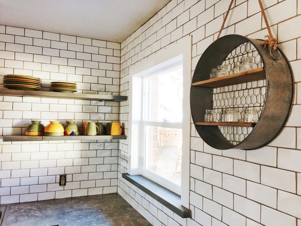 На фото: угловая кухня среднего размера в стиле кантри с накладной мойкой, столешницей из известняка, белым фартуком и фартуком из керамической плитки