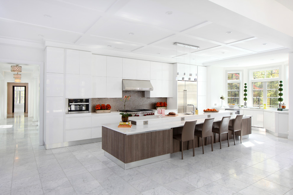Modern inredning av ett mycket stort kök, med en undermonterad diskho, släta luckor, vita skåp, granitbänkskiva, stänkskydd med metallisk yta, stänkskydd i metallkakel, rostfria vitvaror, marmorgolv, en köksö och vitt golv