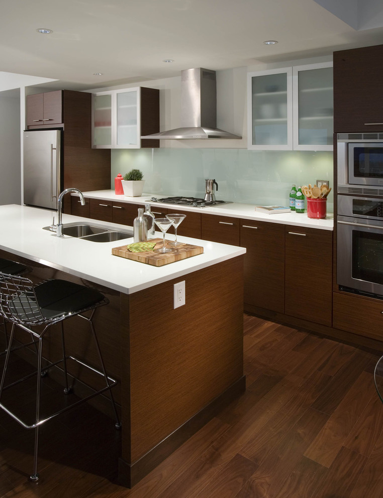 This is an example of a modern kitchen in Vancouver with glass-front cabinets and stainless steel appliances.