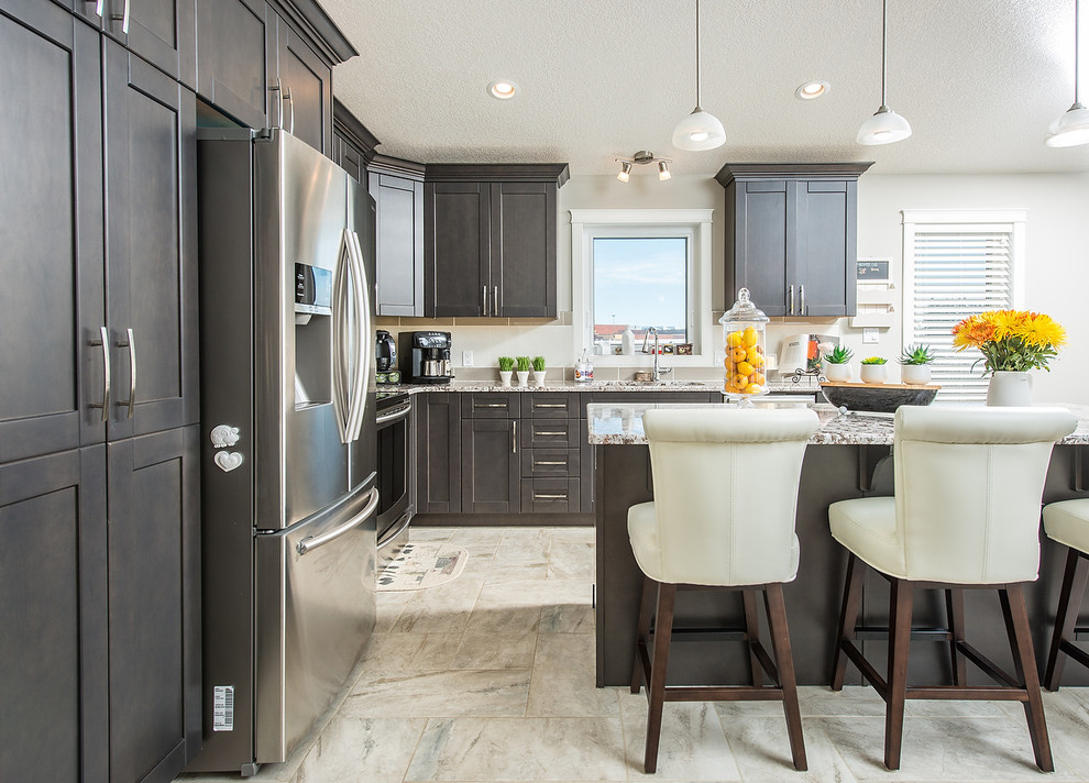 Mittelgroße Moderne Küche in L-Form mit Unterbauwaschbecken, Schrankfronten im Shaker-Stil, dunklen Holzschränken, Granit-Arbeitsplatte, Küchengeräten aus Edelstahl, Keramikboden und Kücheninsel in Edmonton