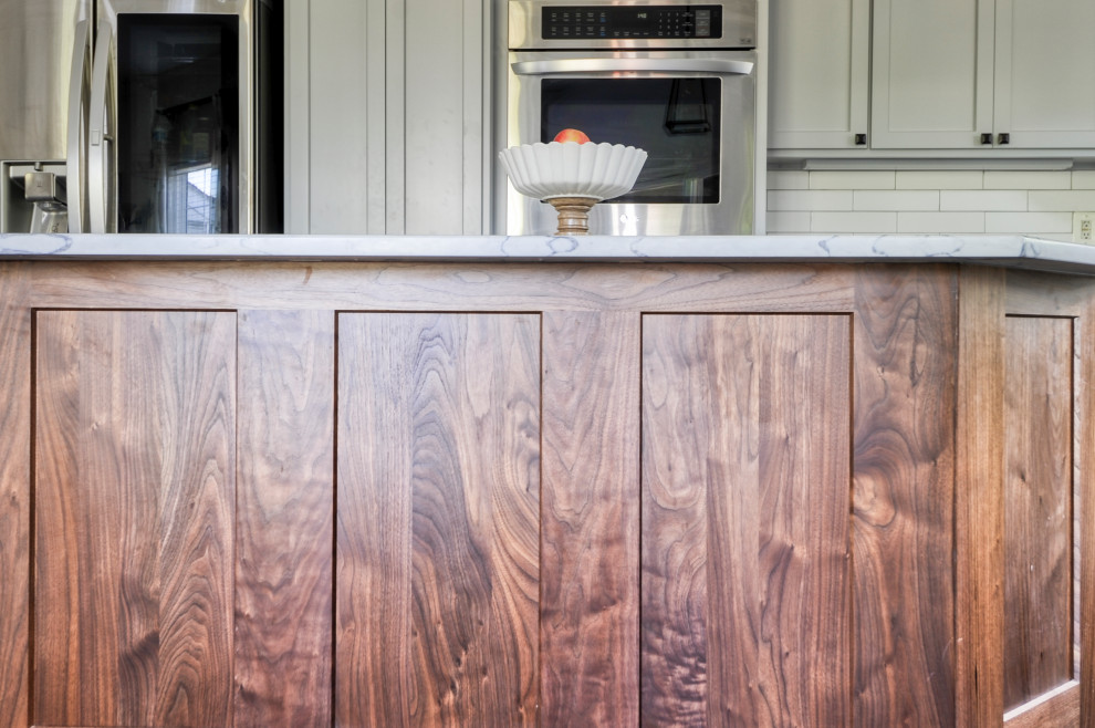 Medium sized rural u-shaped kitchen/diner in DC Metro with a submerged sink, recessed-panel cabinets, grey cabinets, engineered stone countertops, white splashback, metro tiled splashback, stainless steel appliances, dark hardwood flooring, an island, brown floors and white worktops.