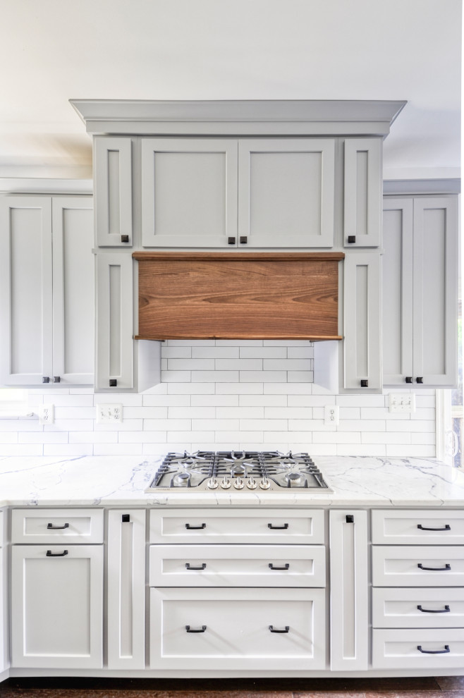 Example of a mid-sized country u-shaped dark wood floor and brown floor eat-in kitchen design in DC Metro with an undermount sink, recessed-panel cabinets, gray cabinets, quartz countertops, white backsplash, subway tile backsplash, stainless steel appliances, an island and white countertops