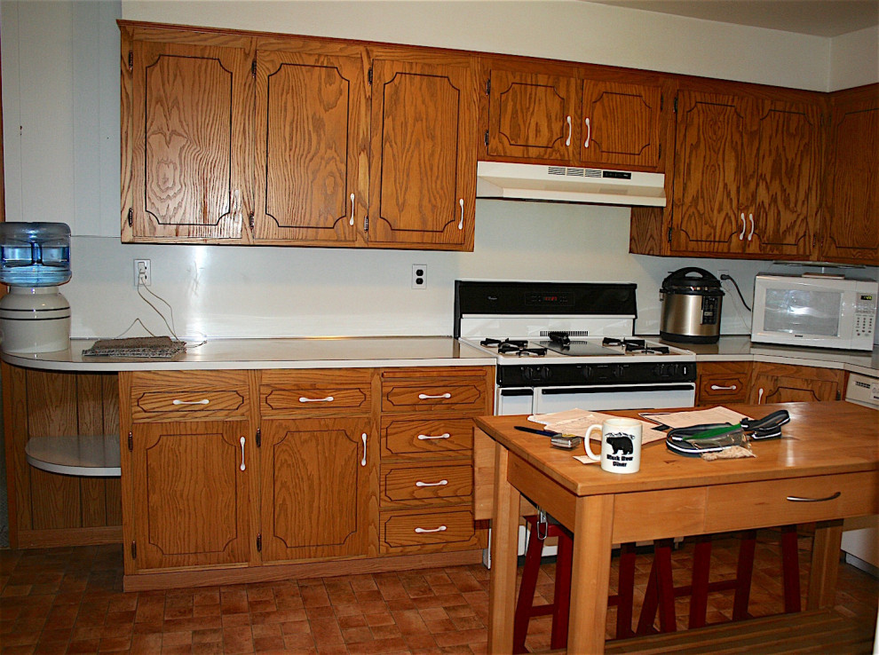 他の地域にある小さなおしゃれなキッチン (ダブルシンク、フラットパネル扉のキャビネット、中間色木目調キャビネット、ラミネートカウンター、白いキッチンパネル、白い調理設備、クッションフロア、オレンジの床、黄色いキッチンカウンター) の写真