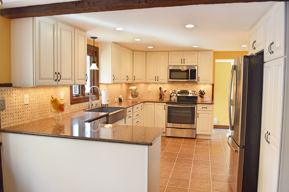 Exempel på ett stort klassiskt brun brunt kök, med en rustik diskho, luckor med upphöjd panel, beige skåp, bänkskiva i kvarts, beige stänkskydd, stänkskydd i travertin, rostfria vitvaror, klinkergolv i porslin, en halv köksö och brunt golv
