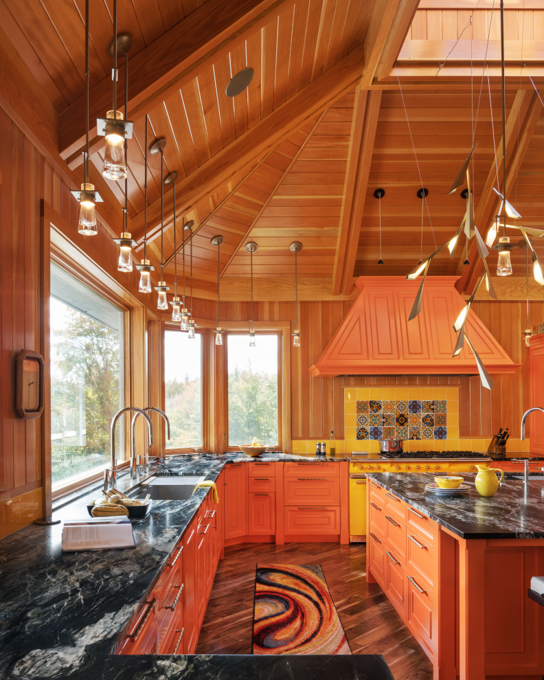 Esempio di un ampio cucina con isola centrale boho chic con lavello sottopiano, ante a filo, ante arancioni, elettrodomestici colorati e soffitto a volta