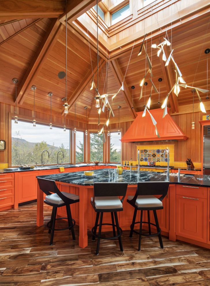 На фото: огромная кухня в стиле рустика с фасадами с декоративным кантом, оранжевыми фасадами, островом и сводчатым потолком с