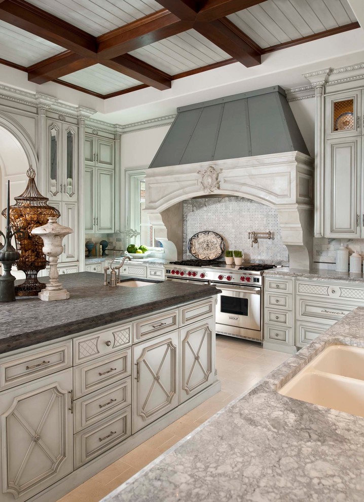 Inspiration for a mediterranean u-shaped enclosed kitchen remodel in Dallas with a double-bowl sink, recessed-panel cabinets, white cabinets, white backsplash, stone tile backsplash and an island