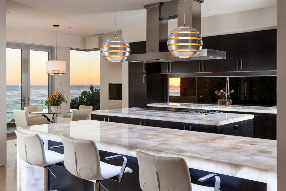 This is an example of a contemporary kitchen/diner in Orange County with flat-panel cabinets, dark wood cabinets and multiple islands.
