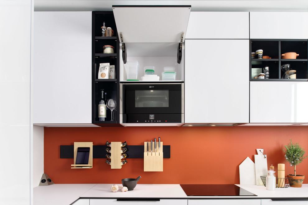 Example of a small minimalist u-shaped terra-cotta tile and multicolored floor eat-in kitchen design in Surrey with a single-bowl sink, flat-panel cabinets, white cabinets, laminate countertops, orange backsplash, stainless steel appliances, a peninsula and white countertops