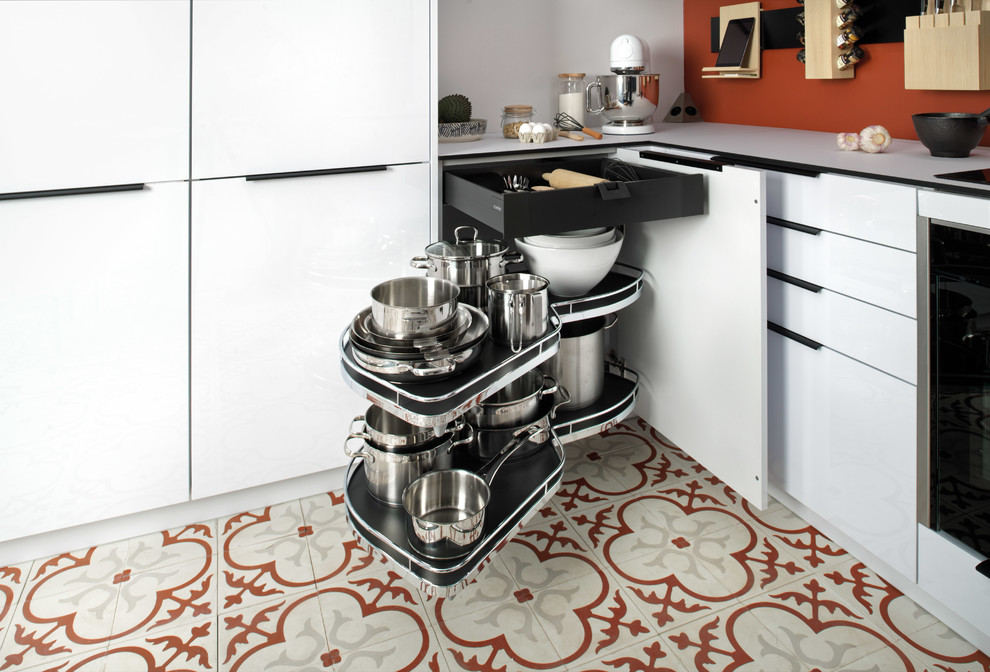 Exempel på ett litet modernt vit vitt kök, med en enkel diskho, släta luckor, vita skåp, laminatbänkskiva, orange stänkskydd, rostfria vitvaror, klinkergolv i terrakotta, en halv köksö och flerfärgat golv