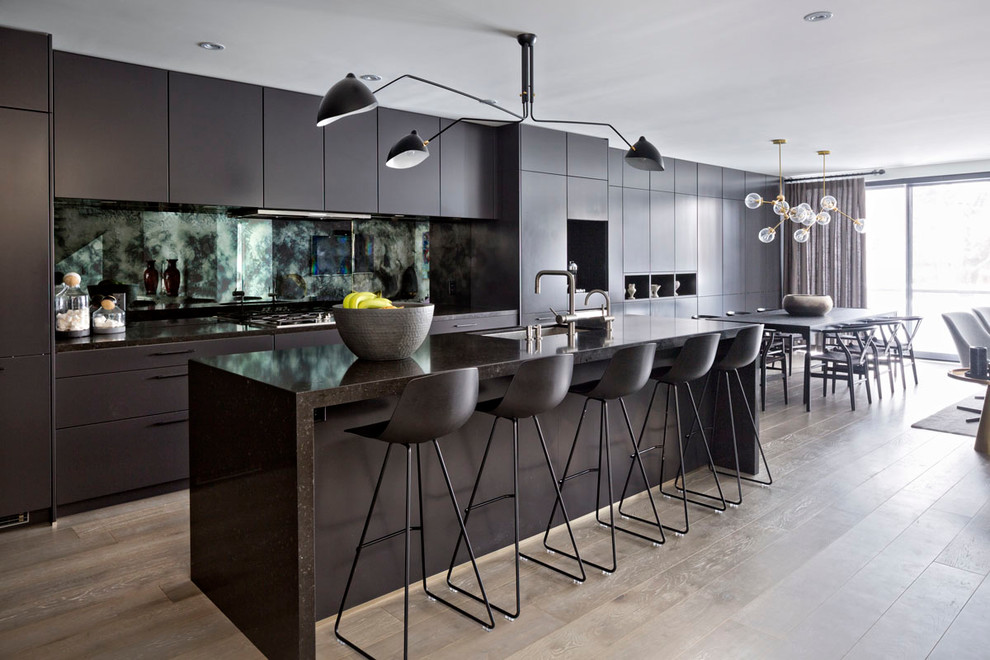 Offene Moderne Küche mit Unterbauwaschbecken, flächenbündigen Schrankfronten, schwarzen Schränken, hellem Holzboden und Kücheninsel in Toronto