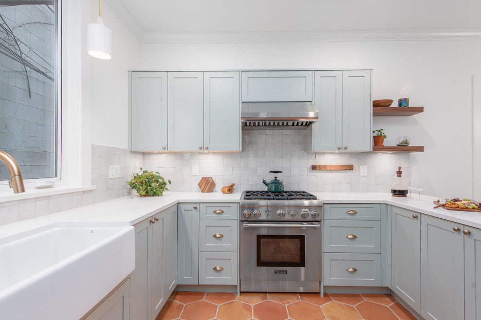 Idéer för att renovera ett mellanstort vintage vit vitt kök, med en rustik diskho, skåp i shakerstil, grå skåp, grått stänkskydd, rostfria vitvaror, klinkergolv i terrakotta, en halv köksö och brunt golv