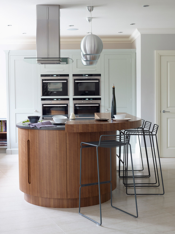 Moderne Küche mit Schrankfronten im Shaker-Stil, blauen Schränken, Kücheninsel und Granit-Arbeitsplatte in London