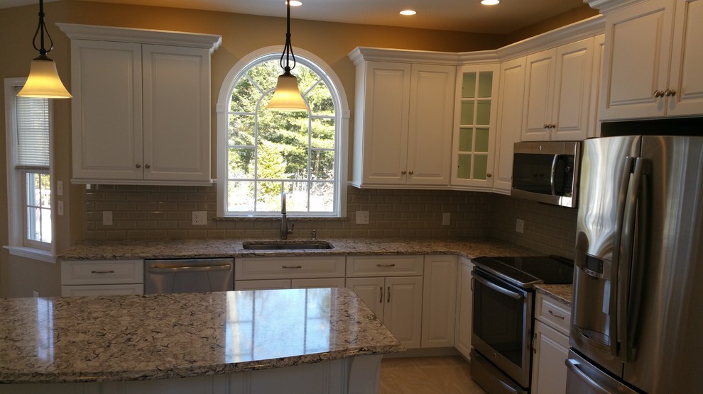 This is an example of a medium sized classic l-shaped kitchen/diner in Bridgeport with a submerged sink, raised-panel cabinets, white cabinets, engineered stone countertops, brown splashback, glass tiled splashback, stainless steel appliances, ceramic flooring and an island.